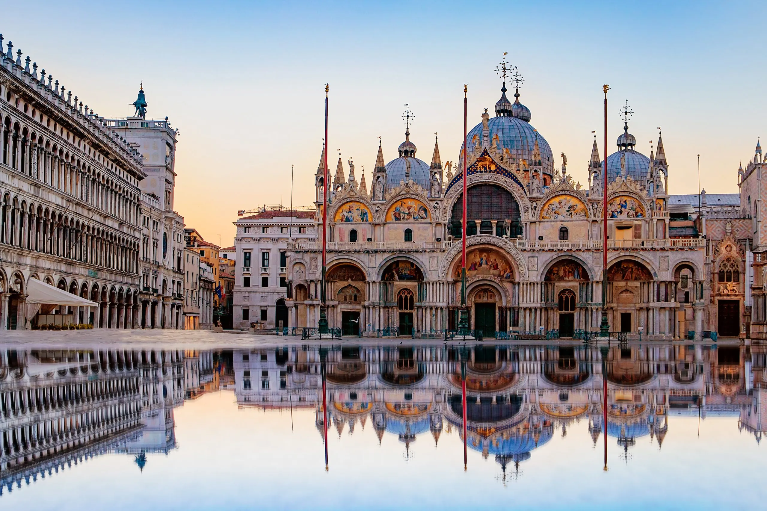 Sonnenaufgang auf dem Markusplatz mit dem Campanile und der Basilika San Marco. Der Hauptplatz der Altstadt. Venedig, Venetien, Italien. Spiegelung auf dem überfluteten Platz.